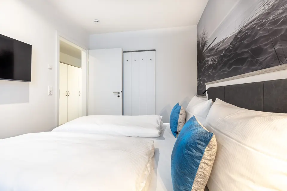 Schlafzimmer mit Fernseher an der Wand